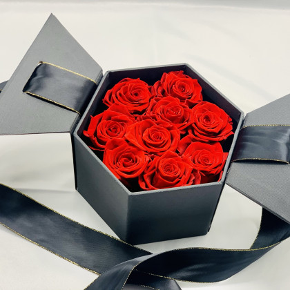 Rosas preservadas rojas en caja hexagonal negra y lazada. Listas para regalar en 24h.