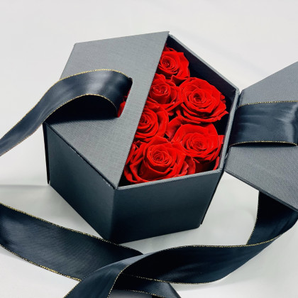 Rosas preservadas rojas en caja hexagonal negra y lazada. Listas para regalar en 24h.