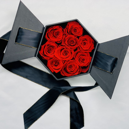 Rosas preservadas rojas en caja hexagonal negra y lazada. Listas para regalar en 24h.